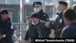 Сотрудники полиции ведут задержанного мигранта. 