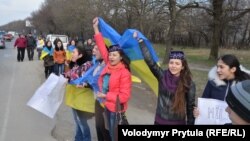 Молоді кримчанки у кримськотатарських національних уборах та з українськими прапорами протестують проти проведення псевдореферендуму в Криму. Околиці Сімферополя, Крим, 14 березня 2014 року