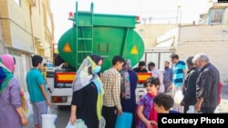 Tehran residents line up for water on June 13. 