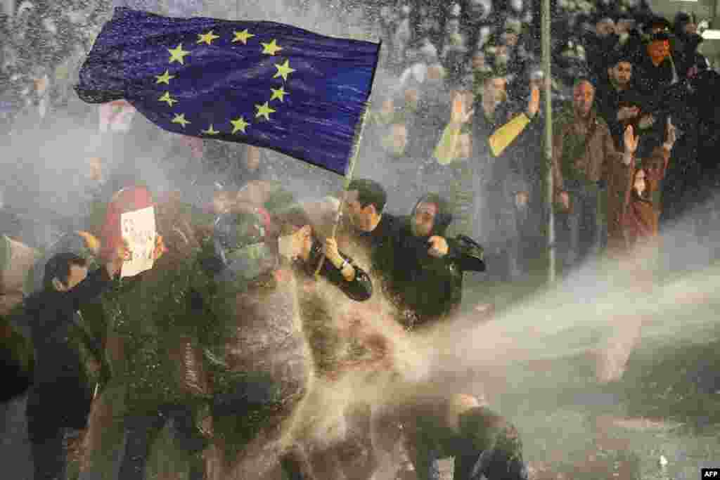 Protesters holding an EU flag are hit with a water cannon during the protest on March 7. The EU's foreign policy chief has called the bill a "very bad development" for the Caucasus country. 