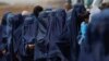 Displaced Afghan women wait in line to receive cash aid in Kabul. (file photo)