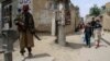 A Taliban member stands guard in an area surrounding a Kabul school after bomb blasts on April 19. At least six people were killed.