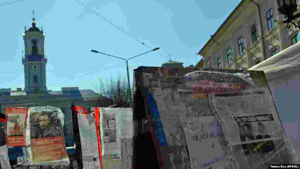 Pe improvizatul “perete al mesajelor” de pe Euromaidanul din Cernăuți pot fi văzute nu doar placate, caricaturi, dar și fotografii, fragmente din ziare. 10 martie 2014, Cernăuți.