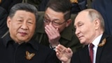 Russian President Vladimir Putin and Chinese leader Xi Jinping talk as they watch the Victory Day military parade in Moscow in May 2025. 