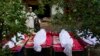 Afghans stand by the bodies of relatives killed in the earthquake in the village of Gayan in Paktika Province.