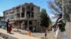 Taliban militants stand guard at the site of an explosion in front of a Sikh temple in Kabul on June 18. 