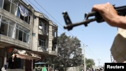 Taliban fighters stand guard at the site of an attack on a Sikh temple in Kabul on June 18.