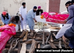 Afghan Sikh men carry the coffins of victims of an attack on a Sikh religious complex before they light a funeral pyre in Kabul on March 26, 2020. Twenty-five worshippers were killed.