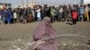 FILE: An internally displaced Afghan woman waits to receive assistance donated by a nongovernmental organization in Kabul.