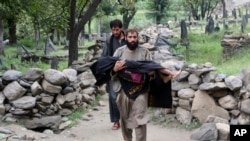 A man in Afghanistan's Kunar Province carries a young victim of an August 31 earthquake that killed many people and destroyed several villages. 