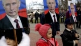 Дети держат портреты президента России Владимира Путина во время митинга в Севастополе. Аннексированный Крым, 23 февраля 2016 года