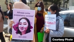 Demonstrators in Osh hold up pictures of 27-year-old Aizada Kanatbekova, who was abducted and found dead.
