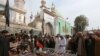 Relatives gather to attend funeral prayers on February 17 for victims killed in a suicide blast at the tomb of Sufi saint Syed Usman Marwandi, also known as the Lal Shahbaz Qalandar shrine, in Sehwan Sharif, Pakistan's southern Sindh Province.