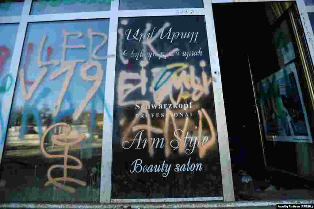 A Hadrut shop window covered in graffiti. 