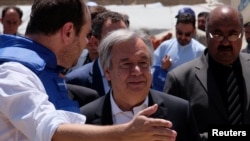 United Nations Secretary-General Antonio Guterres (center) visits a camp for internally displaced people outside Kabul on June 14.