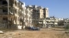 Syria -- Destroyed vehicles and buildings are seen after shelling by Syrian military forces in the Inshaat neighborhood of the restive city of Homs, 05Mar2012