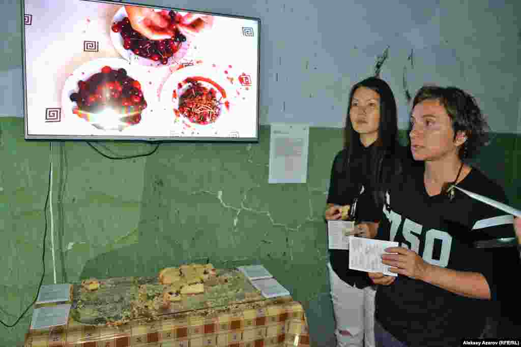 Ресей суретшілер одағының мүшесі Яна Малиновская (Мәскеу) шыққан тегі – ресейлік немістер отбасы. Оның отандастары жыл сайын 28 тамызда 1941 жылы совет үкіметінің Еділ бойындағы неміс ұлттық автономиясын жойып, немістерді депортациялағанын еске алады. Яна Малиновская осынау қасіретті оқиғаға арнаған инсталляциясын «Ұлтты кінәлі жасау» («Национальная провинность») деп атаған. Қабырғада ілінген мониторда шиені сүйегінен тазалап жатқан сәт көрсетілген. Үстел үстінде шиеден жасалған бәлішті одан ауыз тиетіндер үшін кесіп, дайындап қойған. Бәліштің астында – немістерді депортациялау туралы үкімет жарлығы басылған газеттің көшірмесі төселген. Яна Малиновскаяның ата-әжесінің үйінің айналасы толған шие ағашы болыпты. Шие піскен кезде әжесі немістердің дәстүрлі бәліш түрі – ривен кухен әзірлейді екен. Яна Малиновская фотода оң жақ шетте тұр.