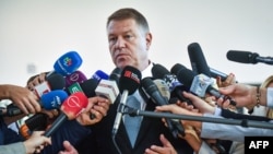 Romanian President Klaus Iohannis speaks to reporters after casting his ballot at a polling station in Bucharest on November 10.