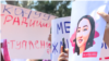 Protesters hold signs depicting Aizada Kanatbekova, who was kidnapped and killed in a suspected "bride kidnapping."