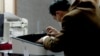 Kyrgyzstan - a worker tries to fix a voting machine in Bishkek during the presidential election. 