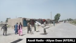 An Afghan soldier removes Taliban flag in the main market area of Nawa on July 17. A checkpoint in the area was attacked by Taliban fighters on July 28.