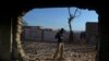 A policeman stands guard at the burnt Hindu temple a day after a mob attack in a remote village in the northwestern Karak district on December 31. (file photo)