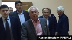 Председатель Союза журналистов Казахстана, президент Национального пресс-клуба Казахстана Сейтказы Матаев (в центре) входит в зал суда. Астана, 23 августа 2016 года.
