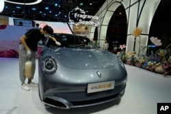 Hytaýyň Şanhaý şäherindäki Milli kongres we sergi merkezinde 2023-nji ýylda geçiriljek Şanhaý awtoulag bazarynda, bir işçi hytaý elektrik ulagy “Ora” maşynyny süpürýär, 2023-nji ýylyň 18-nji apreli.