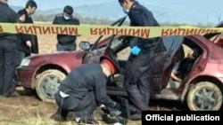 Police carry out investigations on the car in which the bodies were found.